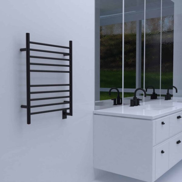 A black Amba Radiant wall-mounted heated towel rack in a white bathroom.