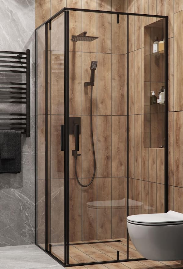 A mock-up of a shower stall in a cabin bathroom with a black heated towel rack beside it.