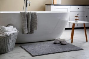A modern bathtub with a memory foam bath mat.